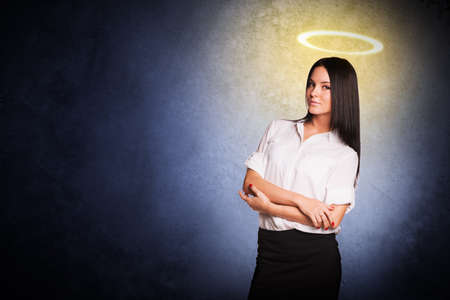 Businesslady with nimbus looking at camera on grey background