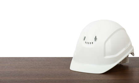 Plastic safety helmet on table isolated on white backgroundの写真素材