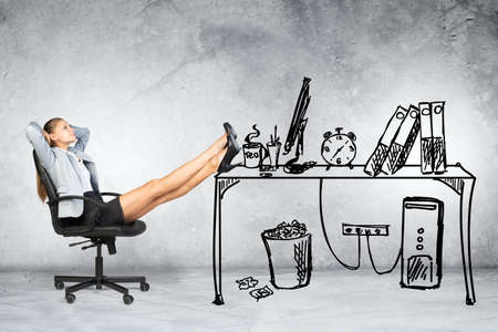 Businesswoman sitting on chair with legs up in drawn officeの写真素材