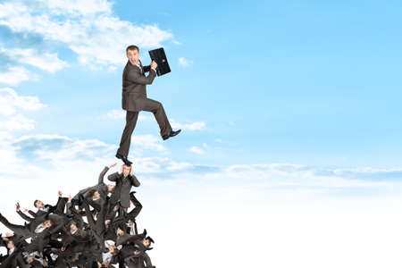 Businessman on pile of people, business concept
