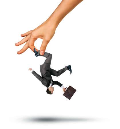 Hand holding little businessman for leg isolated on white backgroundの写真素材