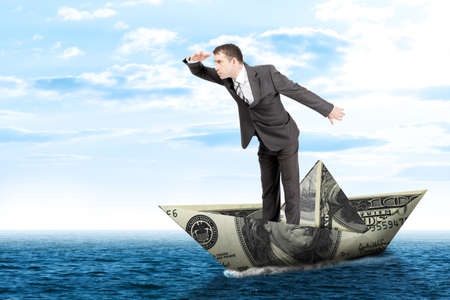 Businessman in dollar boat in blue sea, business conceptの写真素材
