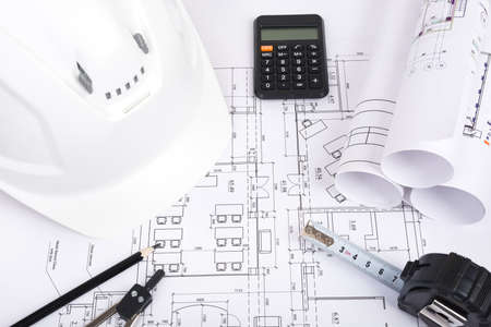 Architecture plan and rolls of blueprints with meter and helmet. Building conceptの写真素材