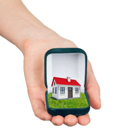 Hand holding ring box with house inside isolated on white background, property concept