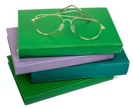 Pile of books with glasses isolated on white backgroundの写真素材