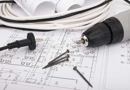 Architecture plan and rolls of blueprints with cabel and electric screwdriver. Building concept