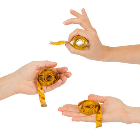 Set of human hands holding yellow measure tape isolated on white backgroundの写真素材