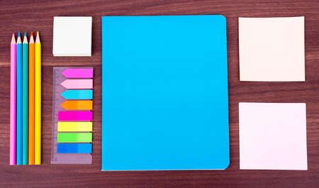 Colorful notebooks with stationary on wooden table background, top viewの写真素材