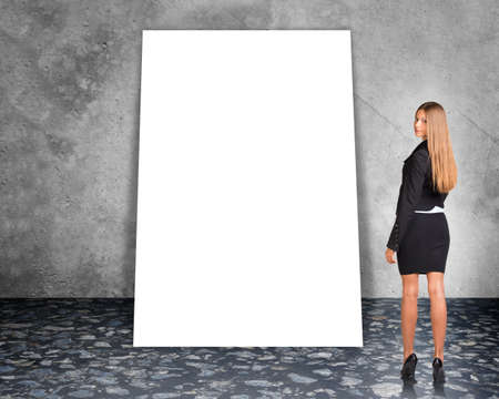Big blank banner with businesswoman in suit on grey wall backgroundの写真素材