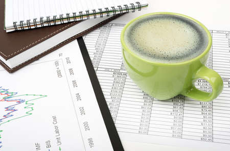 Notebook with coffee on paper bill background, business concept. Close up view
