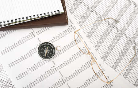 Notebook with glasses and compass on paper bill background, business concept. Closeupの写真素材