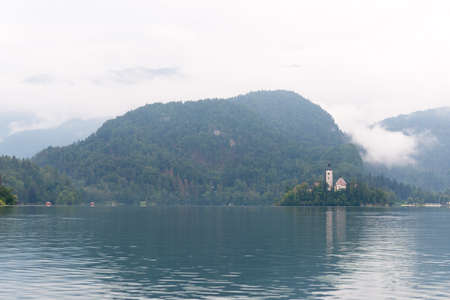 Landscape view with lake and small island on blue sky