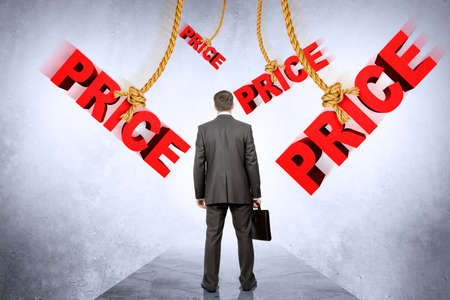 Businessman with suitcase looking on hanging words priceの写真素材