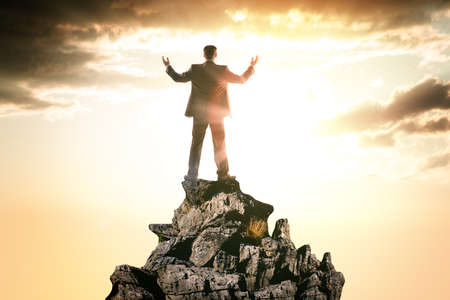 Happy businessman observing morning landscape, rear viewの写真素材