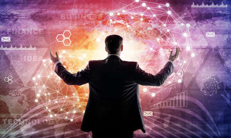 Young businessman raised his hands. Media screen with icons as backdrop. Rear view. Elements of this...