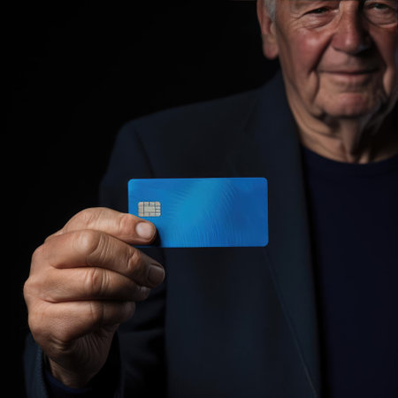 Elderly man holding bank cardの素材