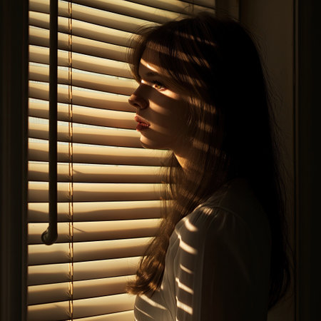 A young woman stands by the windowの素材
