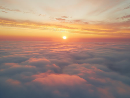 A tranquil sunrise peers over a blanket of clouds with a warm color palette.の素材