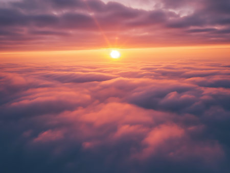 Stunning view of a sun rising over a soft sea of clouds under a warm sky.の素材