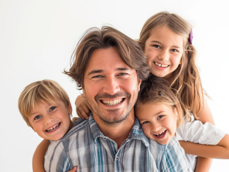 Portrait of a smiling father with his three joyful young children, showcasing a loving family bond and happiness.の素材