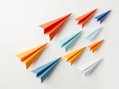 A group of folded paper airplanes with one leading in front, symbolizing leadership and teamwork.の素材