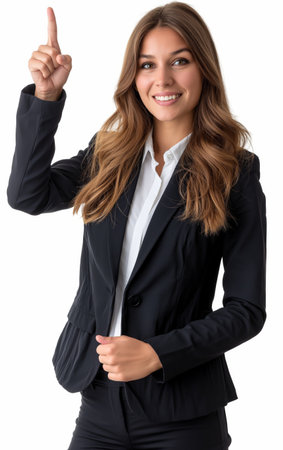A smiling young businesswoman in a suit pointing upwards with her finger, suggesting a new idea or solution.の素材