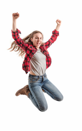 Cheerful young woman in casual attire jumping with her hands raised in a victory pose, expressing joy and success.の素材