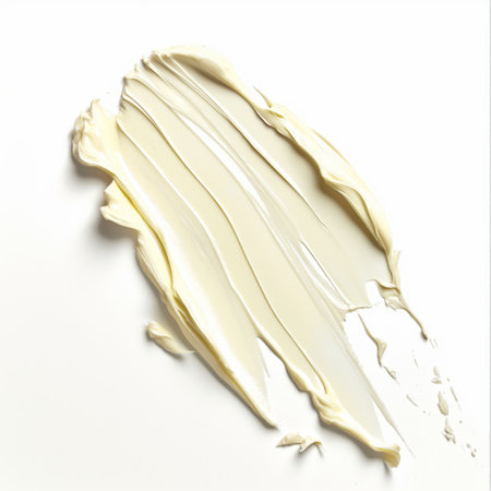 An elegant swipe of beige foundation makeup smeared across a white surface.の素材