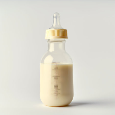 A single baby bottle filled with milk, isolated on a white background, illustrating child care and feeding.の素材