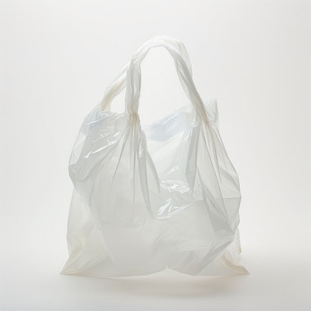 An isolated plastic bag with a knotted handle, emphasizing issues of waste and recycling.の素材