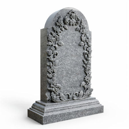 An intricately carved granite tombstone with a blank space for text surrounded by a floral motif.の素材