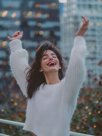 A radiant woman with a joyful expression, stretching arms up, city lights blurred in the background.の素材