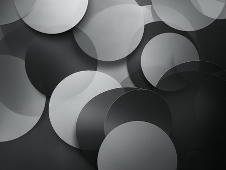 A collection of overlapping circles in shades of black, white, and gray creating a dynamic abstract background.の素材