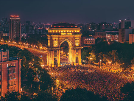 A large crowd gathers around a beautifully illuminated arch in a bustling city at night, creating a vibrant and energetic atmosphere.の素材