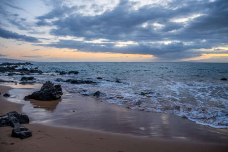 A beautiful view of whitecap waves roll onto the rocky beach of the preserve parkの写真素材