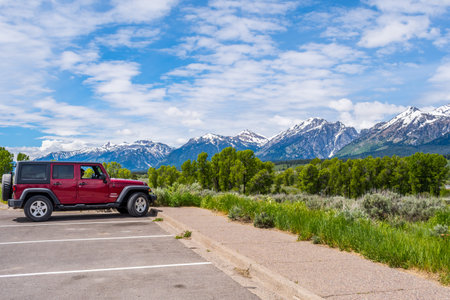 Grand Teton NP, WY, USA - June 22, 2019: A Jeep Wrangler Unlimited Sports parked along the preserve parkのeditorial素材