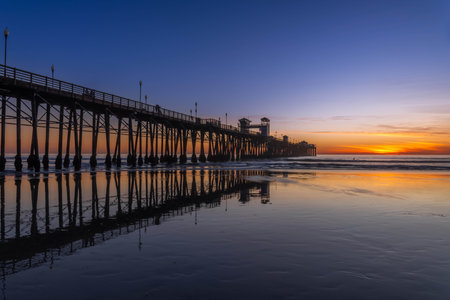 Sunset over a colorful cloudscape in twilight at the shoreの写真素材