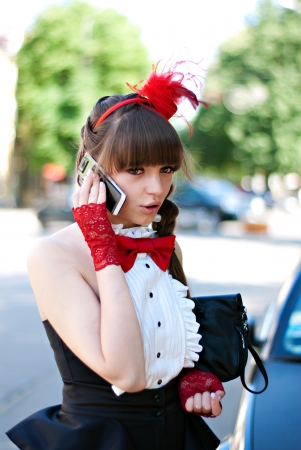 beautiful girl with red bow-tie, cap and glovesの写真素材