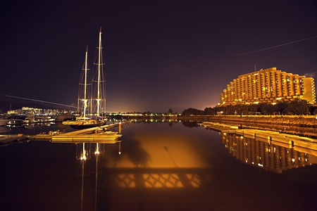 Here is a outlying area away from downtown. A peaceful night at Hong Kong Gold Coast. The sky is full of stars with two planes passing by. The reflection on the sea is so beautiful.のeditorial素材