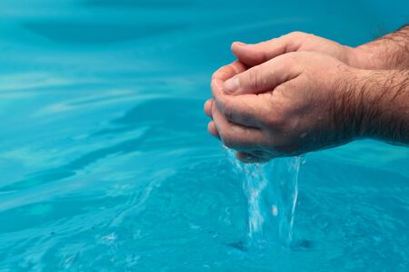 Water is poured from the hands of men.の写真素材