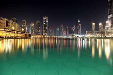 Modern night city of Dubai, with reflection on water surface.の写真素材