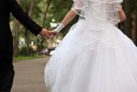Bride and groom holding handsの写真素材