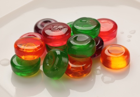 glass colored candies on a white plateの写真素材