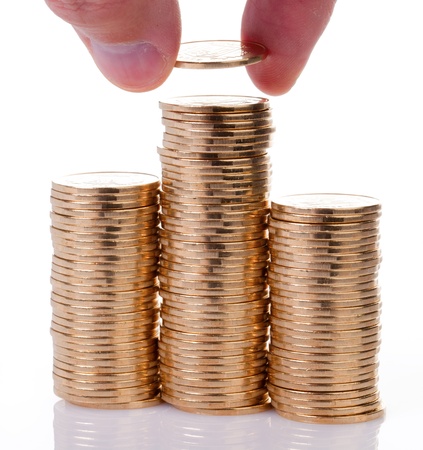 Many gold coins stacked by hand isolated on a white background.の写真素材