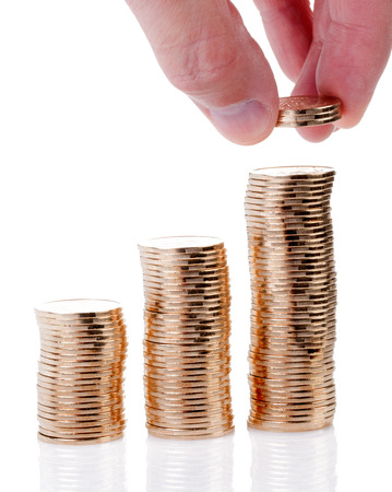 Many gold coins stacked by hand isolated on a white .の写真素材