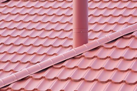 New red Tiled Roof with metal chimney house. Ð¡lose-up texture for construction industryの写真素材