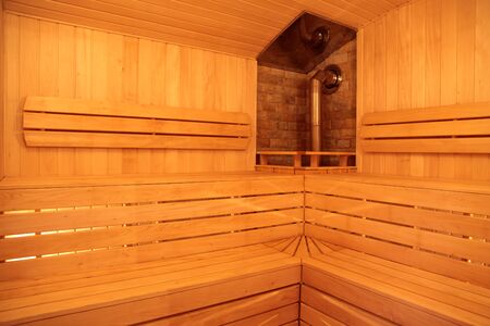 Sauna with a stove with wood shelves for sitting out of linden boardsの写真素材