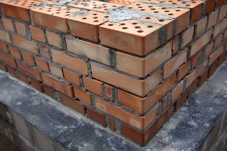 Construction of houses, masonry walls made of red bricks and cementの写真素材