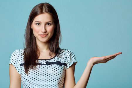 Smiling woman showing open hand palm with copy space for productの写真素材