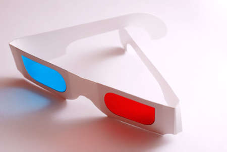 Stereo glasses with blue and red eyes laying on white table